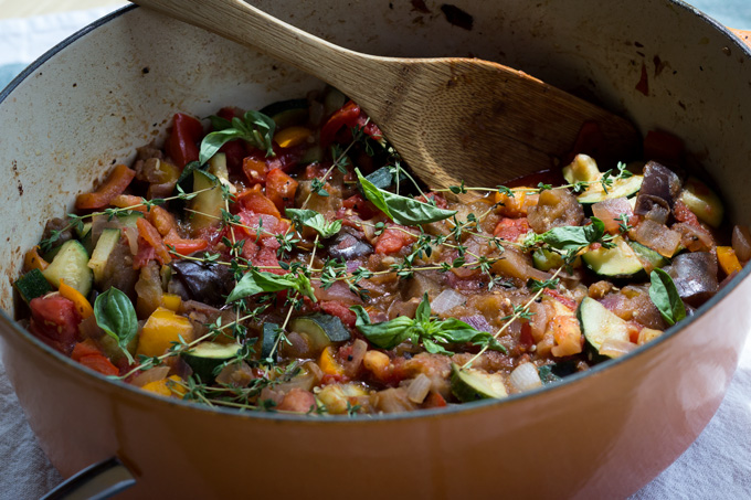 Overhead view of rustic stew in large dutch oven pan with a wooden spatula