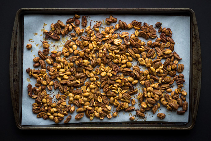 Overhead view of sheet pan with Cracker Jacks Remix spread out on parchment paper and a black background